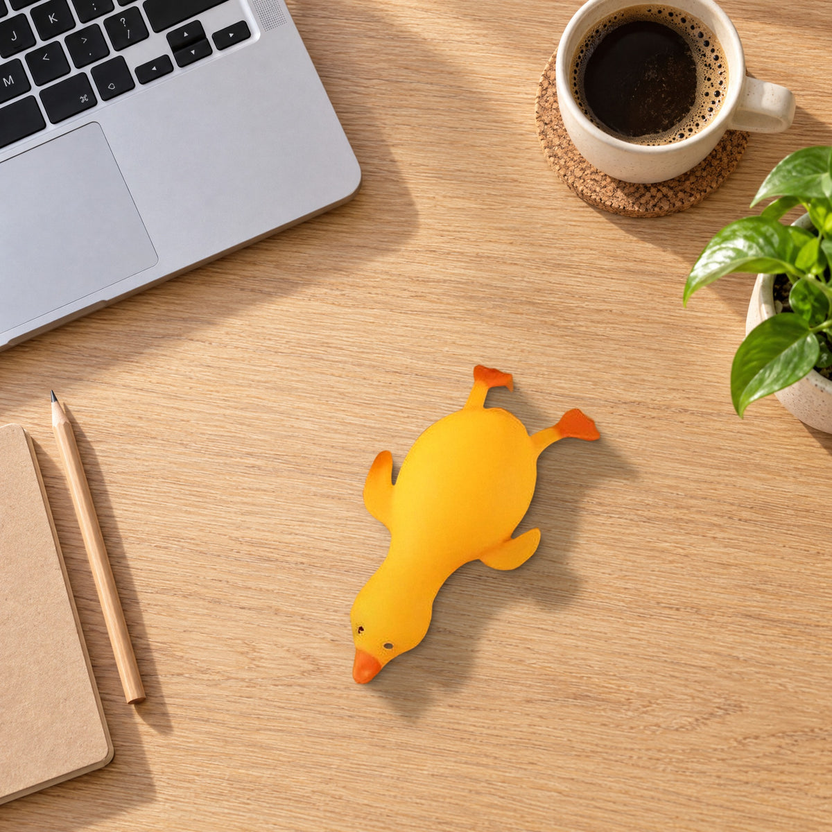 Yellow squishy duck lying flat on an office desk