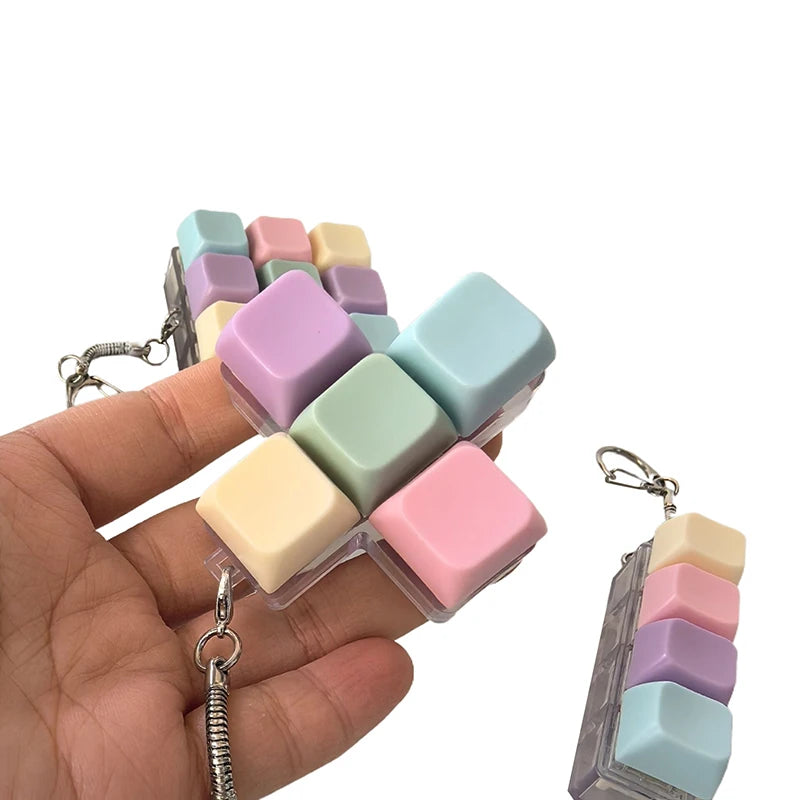 Hand holding a small pastel fidget keychain