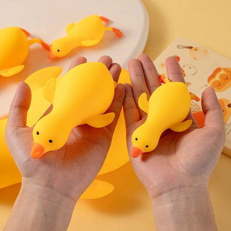 Hands holding yellow squishy ducks